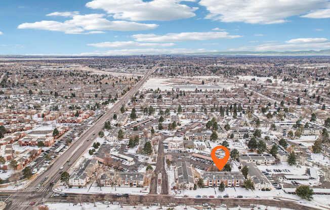 A cityscape with a road running through it and a small orange pin on the right side.