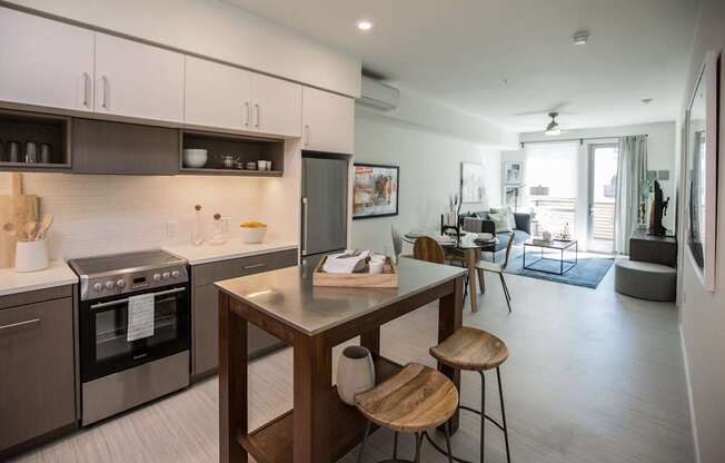 A modern kitchen with a wooden island and stools.