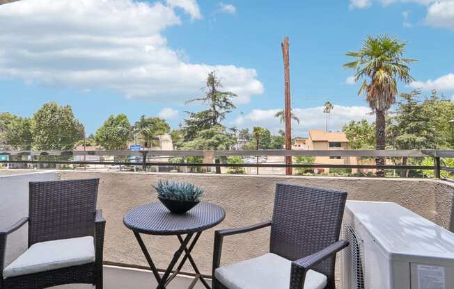 a patio with two chairs and a table on a balcony