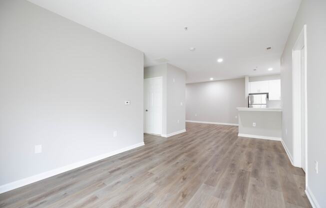 an empty living room with white walls and wood flooring