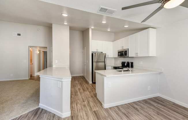 Kitchen with View of Entryway, Wood Inspired Floors, Ceiling Fan/Light and Refrigerator