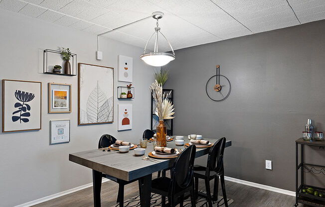 A dining room with a table set for a meal.