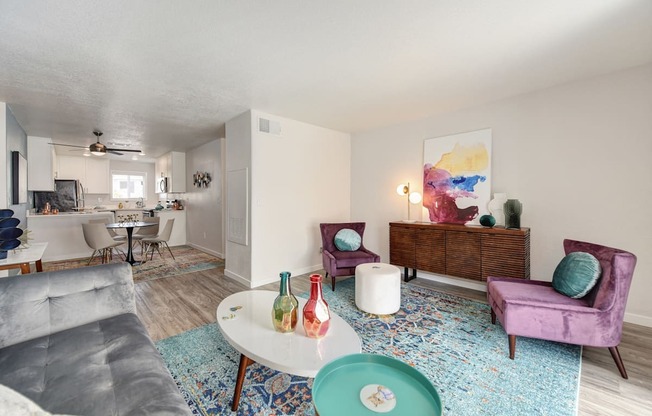 Living Room with Blue Pattern Rug, White Table, Gray Sofa, Purple Chair and Round Wall Mirrors