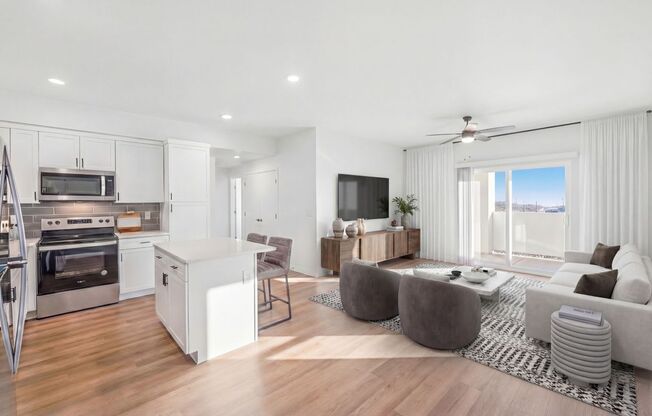 Chic open-plan living area with a modern kitchen, stylish furnishings, and a large wall-mounted TV, exuding comfort and elegance at Summit on Boulder Apartments near Las Vegas