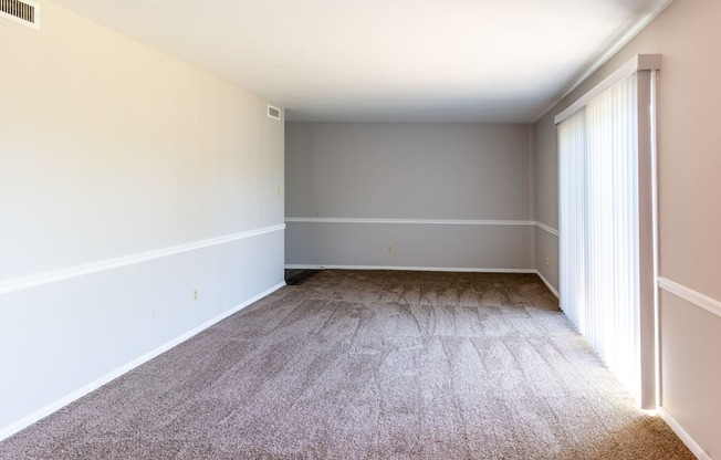 an empty room with carpet and a window