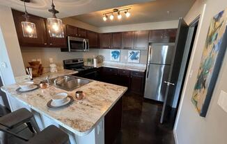 a kitchen with stainless steel appliances and granite counter tops at Palisades at Pleasant Crossing, Rogers Arkansas