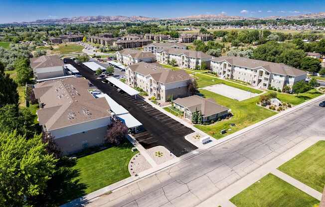 A large apartment complex with a parking lot in front.