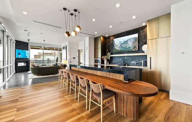A modern kitchen with a long wooden island and chairs.
