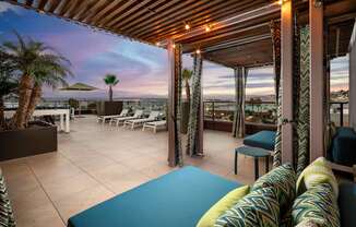 A patio with a blue cushion and a striped pillow.