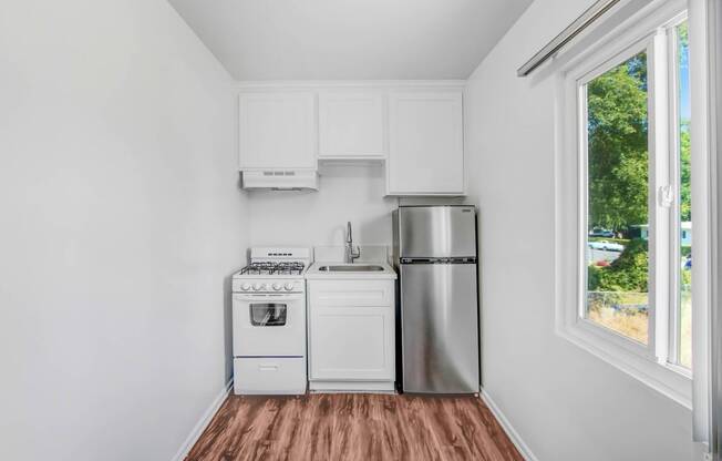 a kitchen with a stove refrigerator and a window