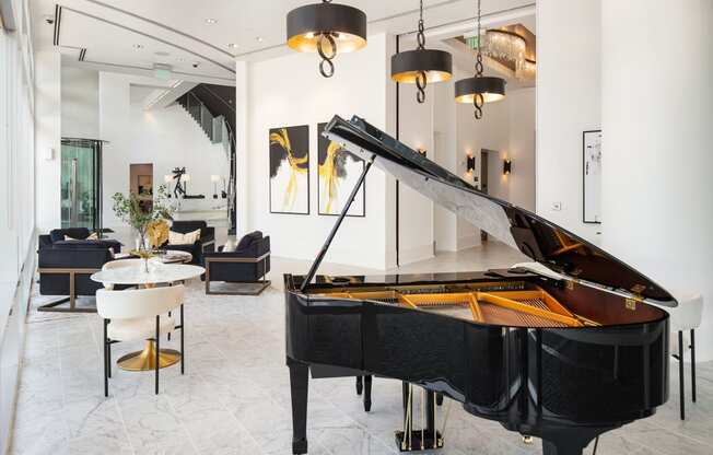 a large black piano in a living room with chairs and a table