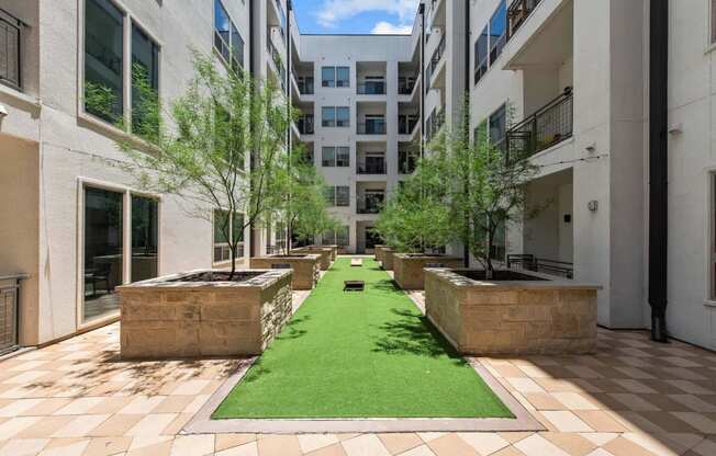 a courtyard with grass and trees in an apartment building