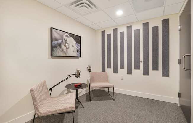 a room with two chairs and a table and a picture on the wall