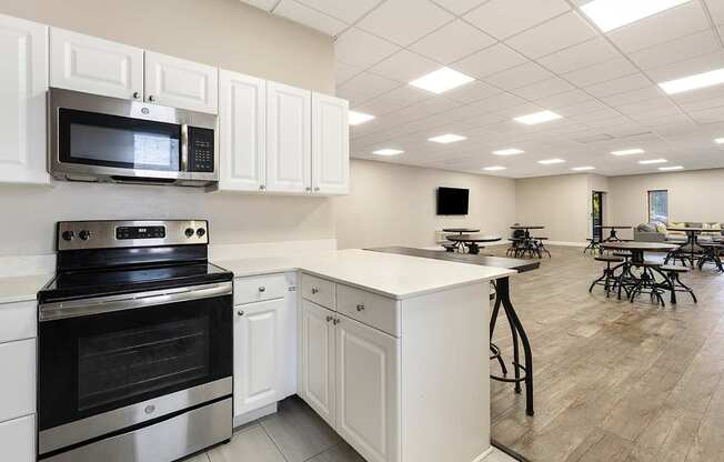 A kitchen with white cabinets and a black stove top oven.