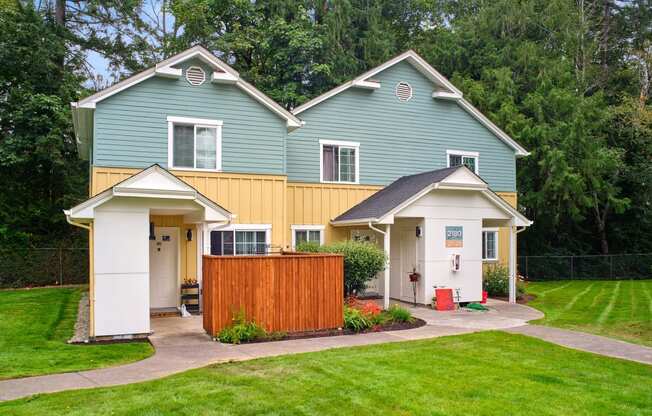 a blue and yellow house with a yard and a wooden fence at Woodcreek, Washington, 98370