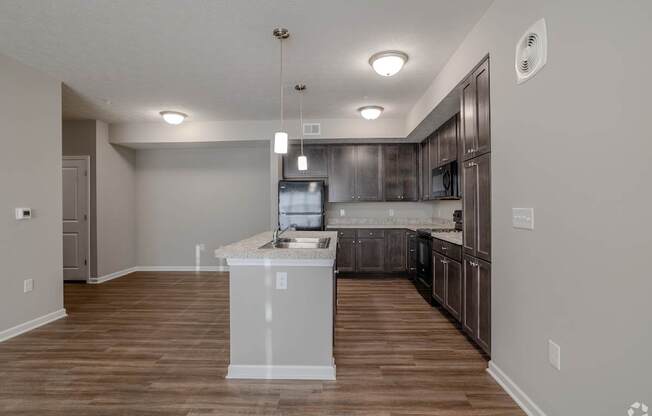 A kitchen with a white island at The Residences at Akita Lane, Canal Winchester, OH 43110