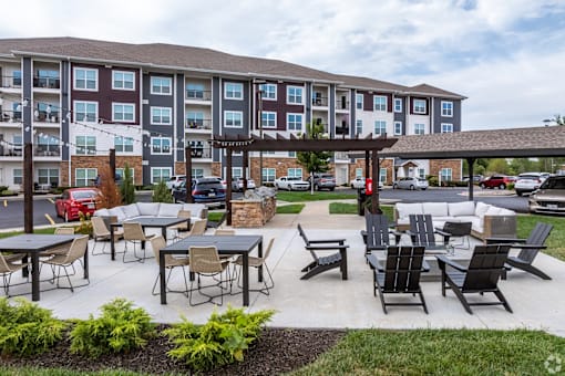 an outdoor patio with tables and chairs at an apartment complex