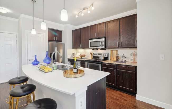 an open kitchen with a large white island and wooden cabinets