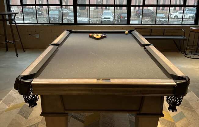 a pool table sits in front of a large window in a room with a checkered