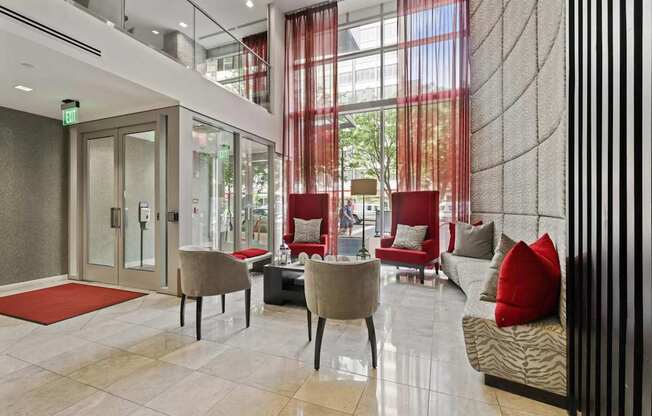 A modern living room with a glass door and a red rug.