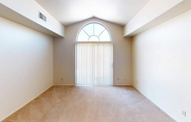 A living room with a large window and a cathedral ceiling at Foxwood and The Hermitage, Portage, MI