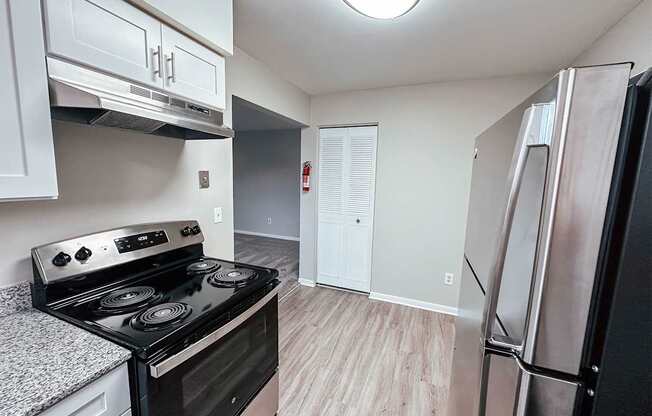 A kitchen with a black stove top oven and a refrigerator.