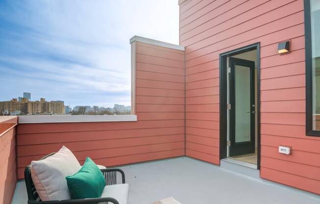 a balcony with a couch and a chair and a door