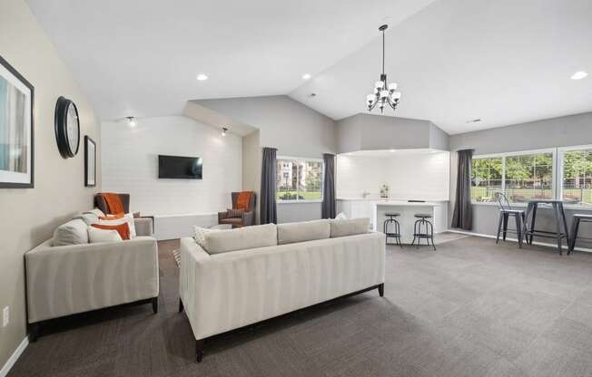 a large living room with white couches and a dining room