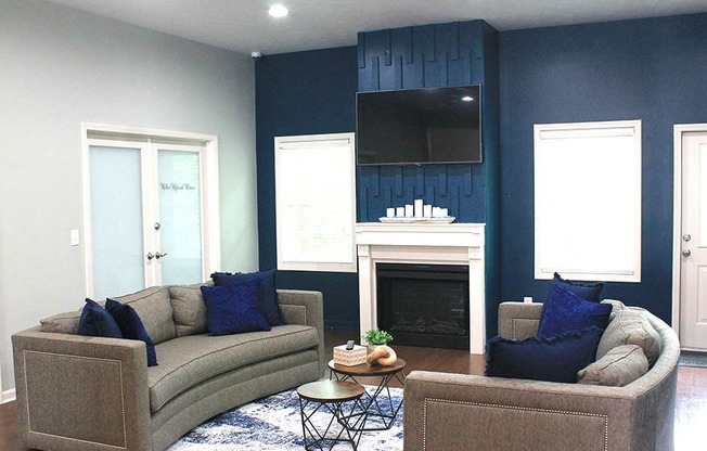 a living room with blue walls and a fireplace with a tv above it