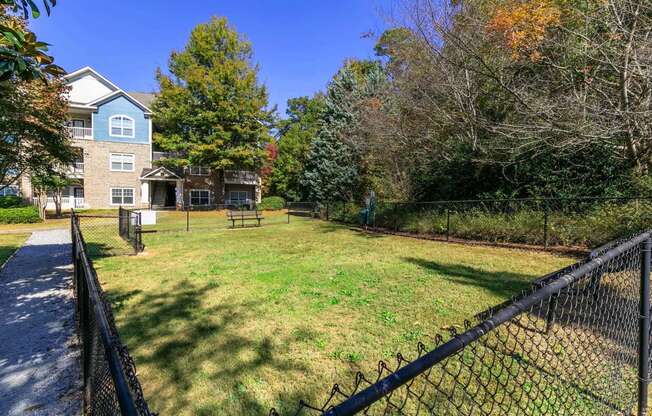 a yard with a fence and a house in the background