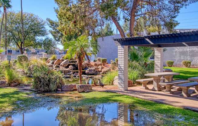 a park with a pond and picnic table