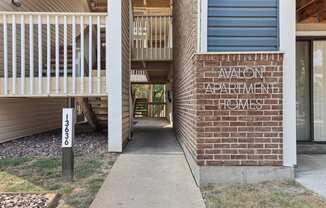 the entrance to an apartment building with a walkway to the front door at The Avalon Apartment Homes, Chesterfield, MO 