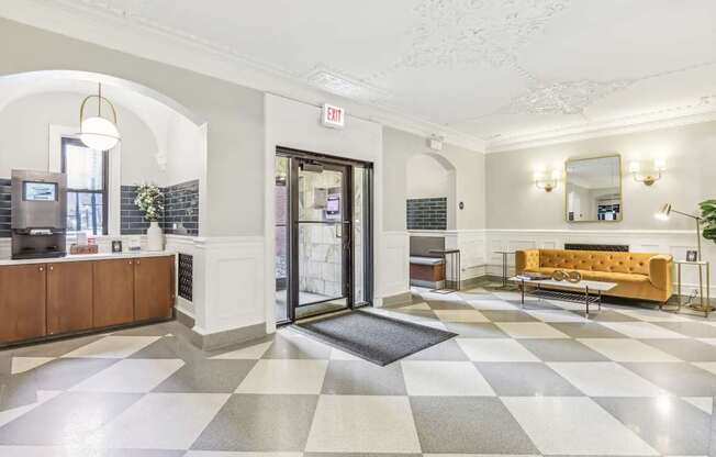 A white and black checkered floor in a lobby with a yellow couch.