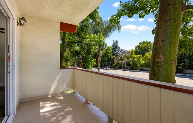 a balcony with a tree next to a building