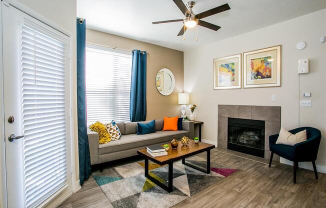 a living room with a fireplace and a ceiling fan