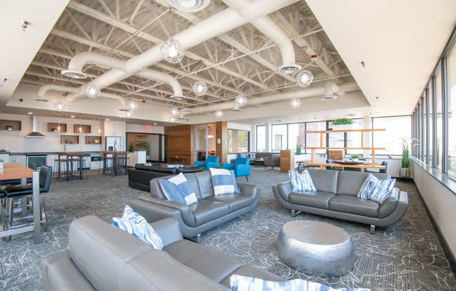 A spacious room with grey couches and a patterned carpet