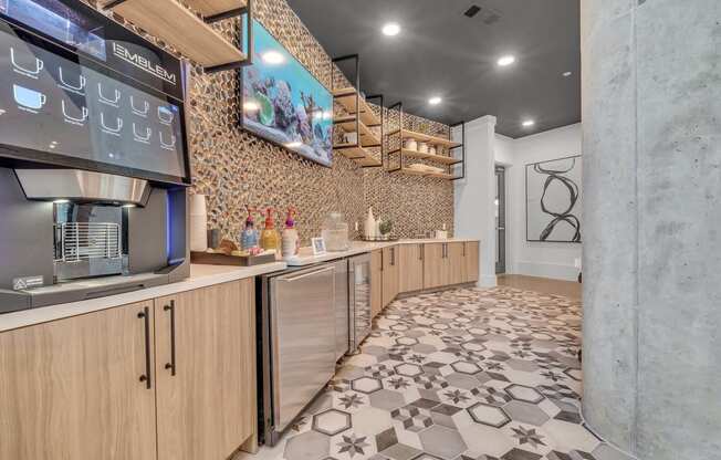 a kitchen with a coffee machine and a tv on the wall