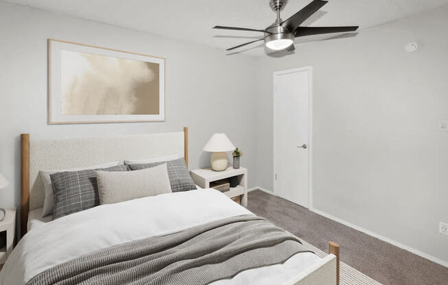 Model apartment bedroom with a bed and a ceiling fan