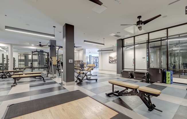 a spacious fitness center with exercise equipment and a black and white checkered floor