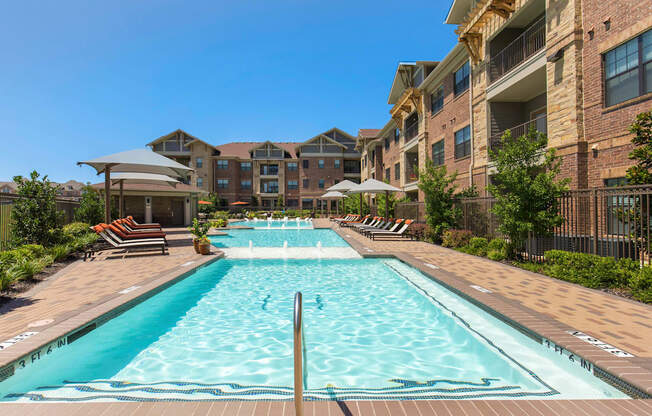 a large swimming pool in front of an apartment building