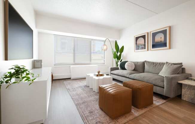 a living room with a gray couch and a large window