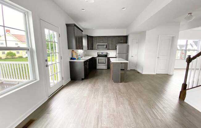 A kitchen with a refrigerator, oven, and microwave.