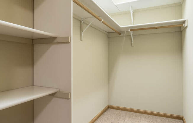 a walk in closet with empty shelves