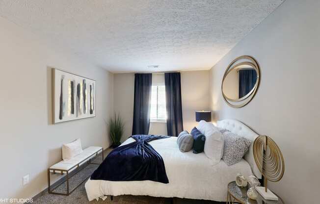 a bedroom with a bed and a mirror on the wall