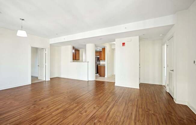A large empty room with wooden floors and white walls.