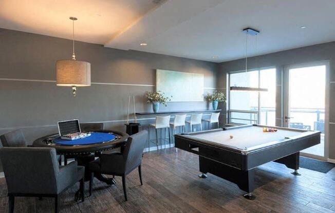 a living room with a pool table and a bar