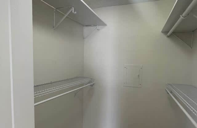 an empty closet with shelves and a shelf on the wall