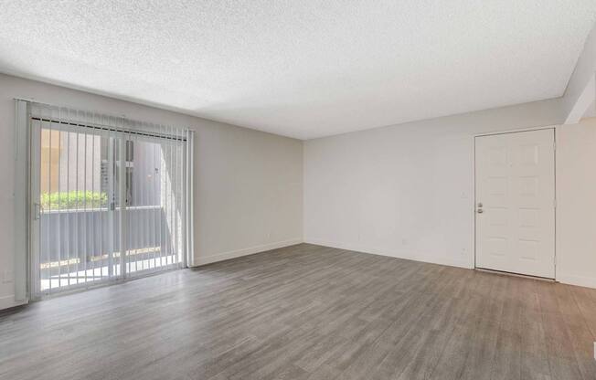 A room with a sliding glass door and a wooden floor.
