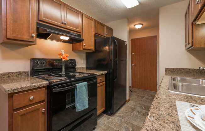 Kitchen with Black Appliances at Parkview Arms Apartments in Bismarck, ND