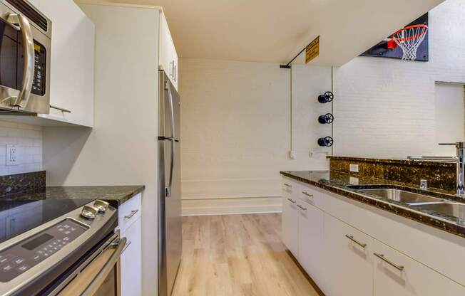 Modern kitchen with white cabinets and a black counter top.